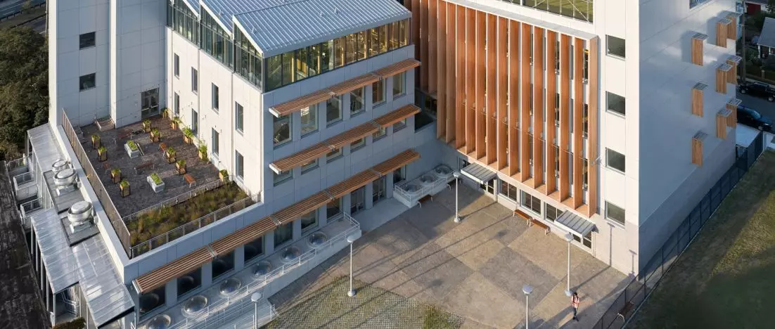 Drewniana szkoła z boiskiem na dachu. Evergreen Charter School w Hempstead projektu Martin Hopp Architect