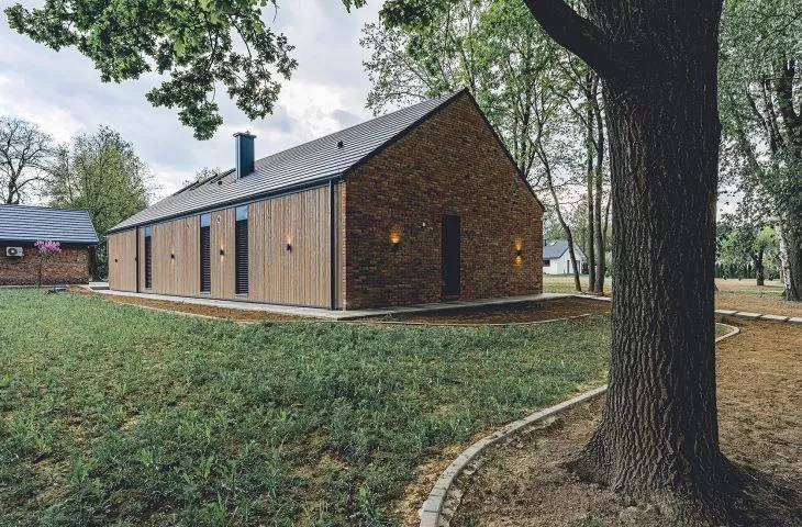 A brick barn in the Lublin region. A modern house inscribed in an old habitat