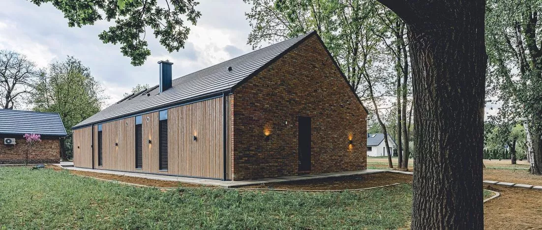 A brick barn in the Lublin region. A modern house inscribed in an old habitat