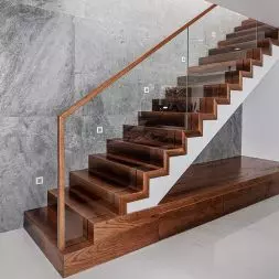 Betonowa konstrukcja schodów z obłożeniem z Jesionu Thermo i szklaną balustradą