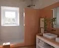 Okładziny ścian (Dekton Umber) połączone z umywalkami nablatowymi Silestone Marie TOP (Blanco Zeus)