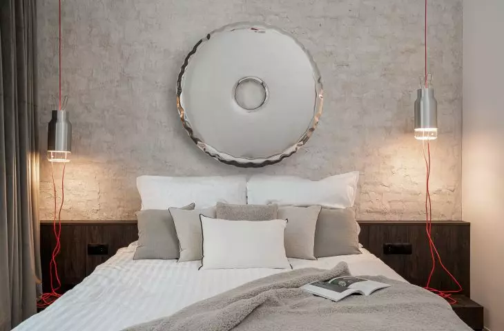 In a central place above the bed is a mirror Rondo by Oskar Zięta