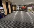 Przykład dużych powierzchni wycieraczek w wejściu do centrum handlowego