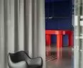 The famous RM58 chair, with a wall of kitchen spatulas in the background
