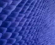Thousands of evenly stacked navy blue spatulas form a wall