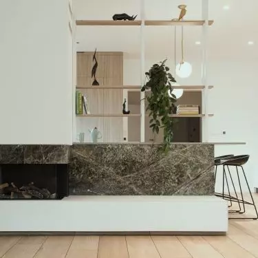 The kitchen island and fireplace are joined by marble