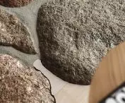 raw, irregular stones in the living room are juxtaposed with a smooth, bright floor surface