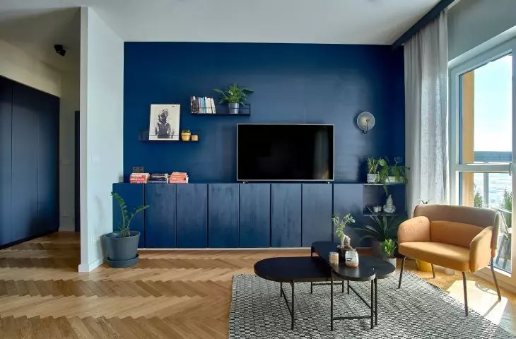 The living room area's cabinetry has been painted blue