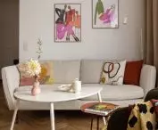 w salonie nad kremową kanapą umieszczono kolorowe ilustracje autorstwa Karoliny Pawelczyk