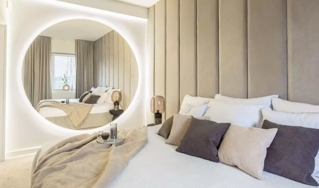 In the bedroom there is a large illuminated mirror
