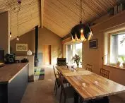 Ecomodus panels and a house built using strawbale technology; houses built using this method are valued for their energy efficiency, quick construction time, use of renewable, biodegradable materials, and optimal, healthy indoor environment