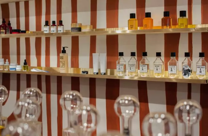 niszowe perfumy stoją na mosiężnych półkach