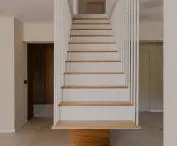 the staircase consists of two parts - the upper, steel part and the lower, wooden part