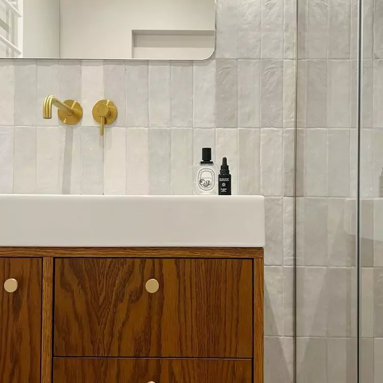 The decor of the bathroom relates to the kitchen
