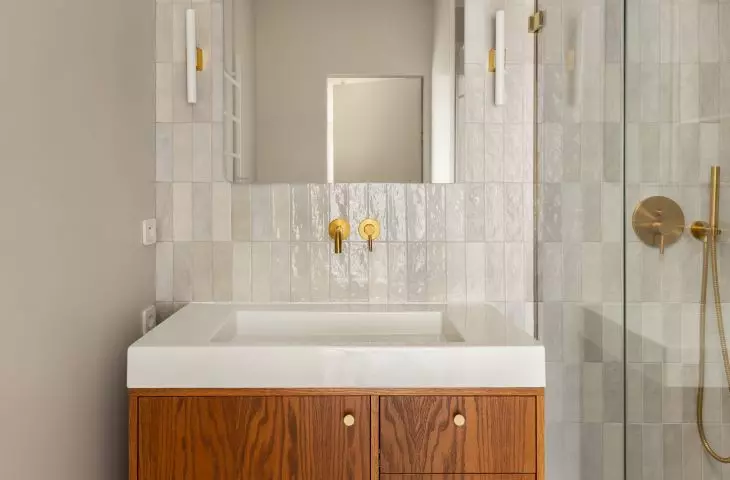 The bathroom is dominated by wood and gold