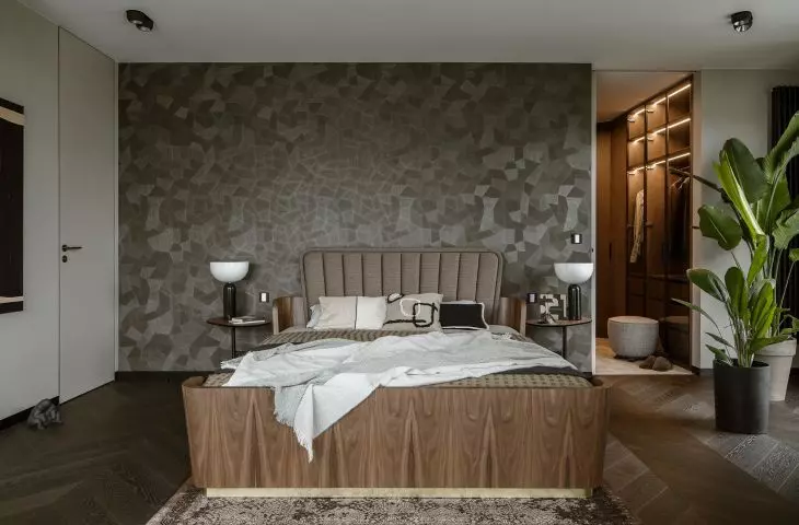 Behind the bed is a mosaic wallpaper
