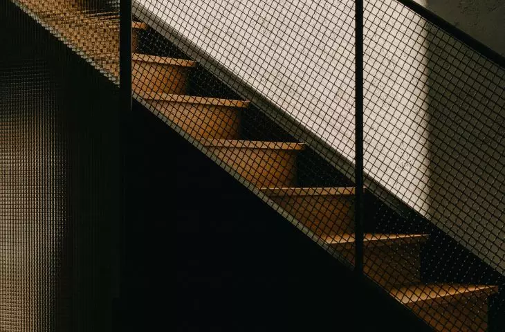 the stairs are crowned with a balustrade made of technical steel mesh