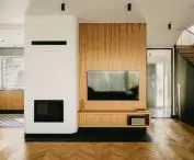 in the living room, the eye is attracted by the white fireplace surround with gently curved corners