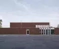 A brick wall separates the office building from the industrial zone