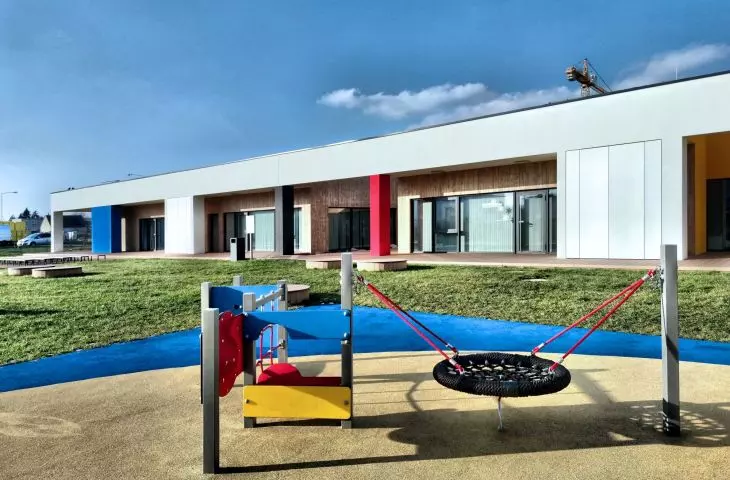 Color accents appear on the façade and in the nursery's surroundings