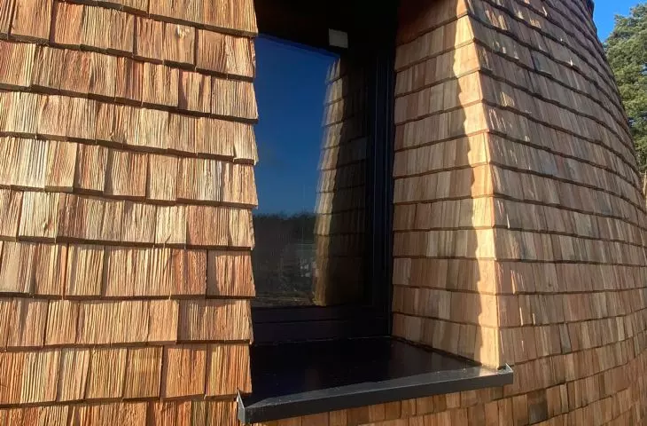 A fragment of an elevation covered with aspen shingles