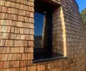 A fragment of an elevation covered with aspen shingles