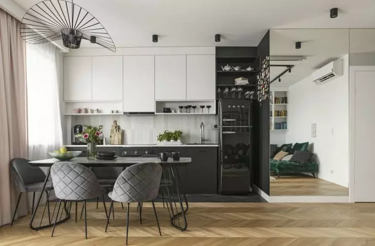 The kitchen area is defined by a dark strip of tiles