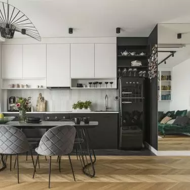The kitchen area is defined by a dark strip of tiles
