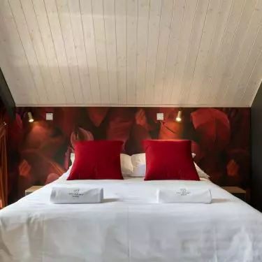 Bedroom with wallpaper with banana leaf motif