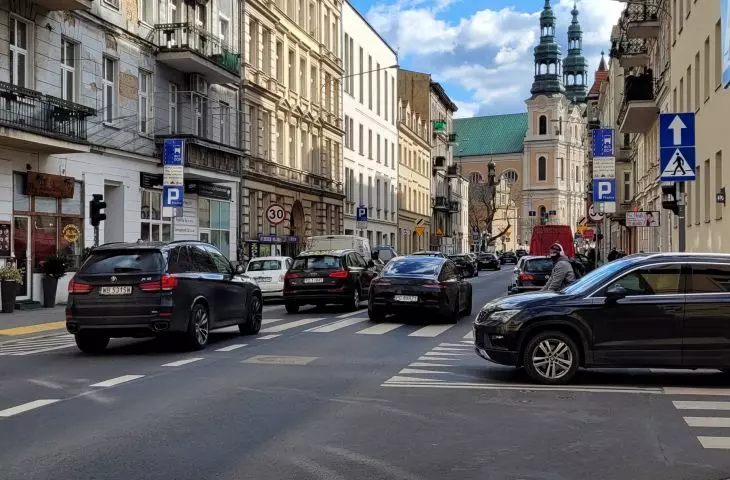 Ulica Garbary obok rewaloryzowanej kamienicy, widok na kościół Franciszkanów (d. Bernardynów)