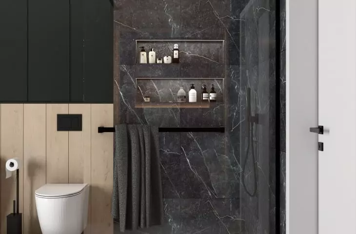 The shower area is lined with black tiles