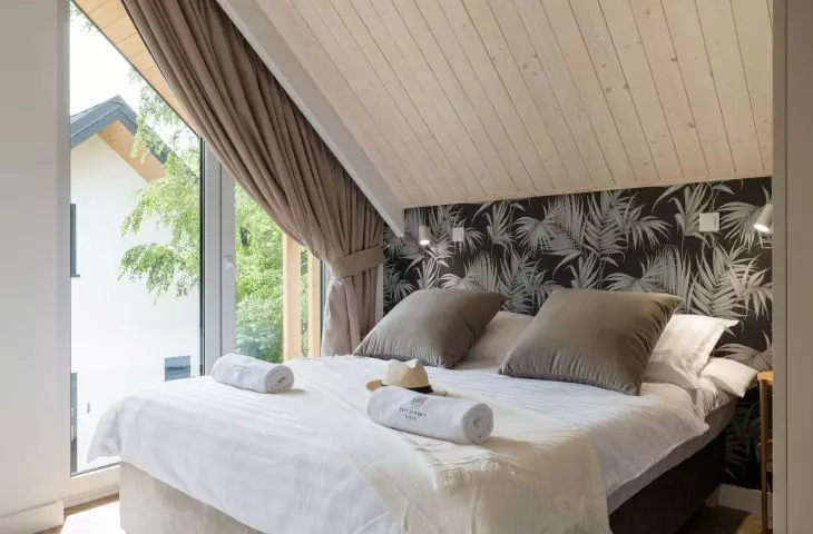 Bedroom with wallpaper with a plant motif
