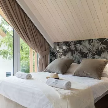 Bedroom with wallpaper with a plant motif