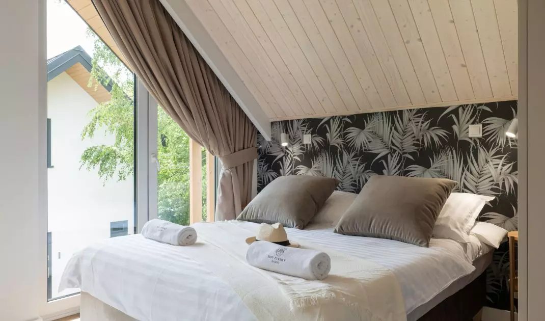 Bedroom with wallpaper with a plant motif