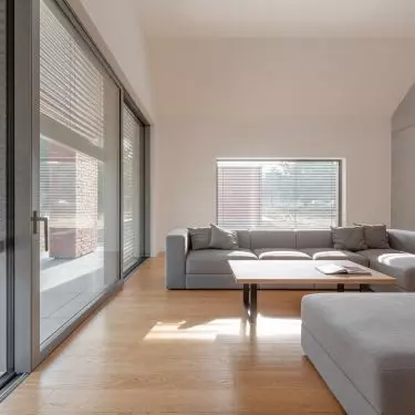 The living room has large glass windows