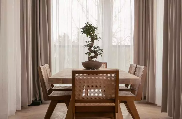 The dining space features a large wooden table and a crystal chandelier