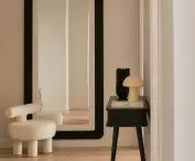 In the lobby there is a large mirror in a black frame