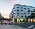 a residential building on Fabryczna Street in Poznań; the characteristic elements of the facade are the inter-storey strips made of aluminum, surrounding the balconies