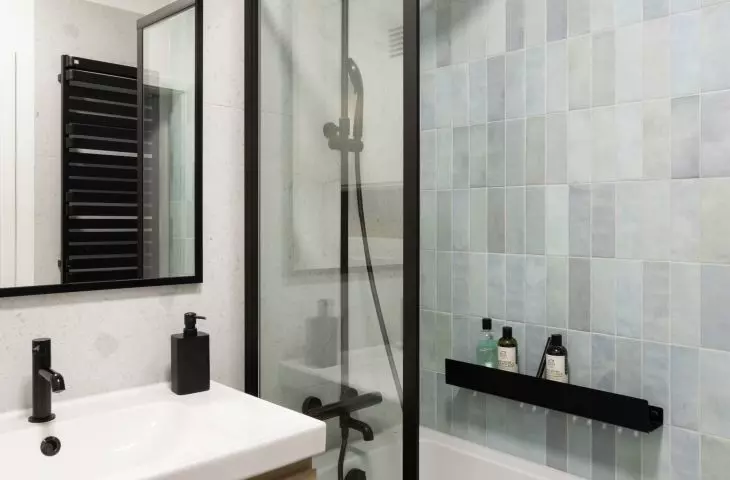 The bathing area has been tiled with mint-colored tiles 