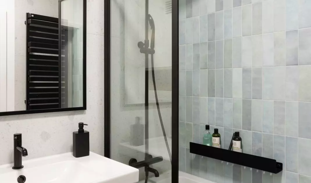 The bathing area has been tiled with mint-colored tiles 