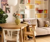 in the white and yellow bookcase next to books and colorful accessories there was a place for a cat bed