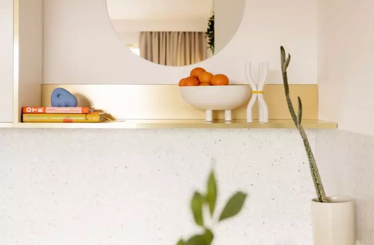 decorative gold shelf and round mirror in the kitchen