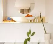 decorative gold shelf and round mirror in the kitchen