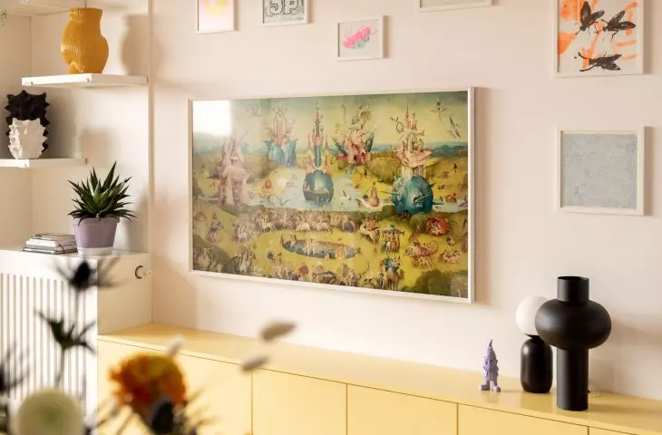 a home gallery of graphics and posters was created above the yellow cabinet
