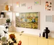 a home gallery of graphics and posters was created above the yellow cabinet