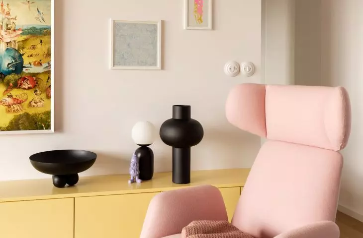 pink armchair on the background of the home gallery of posters and graphics