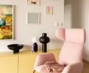 pink armchair on the background of the home gallery of posters and graphics