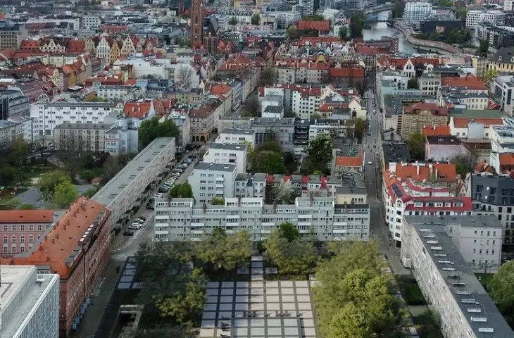 newly planted greenery to form a ring around the center of the square