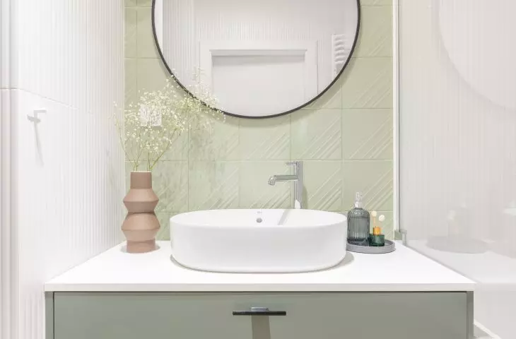 The round countertop washbasin is complemented by a silver faucet 