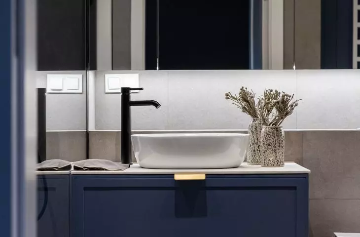Mirrored cabinet fronts optically enlarge the bathroom space